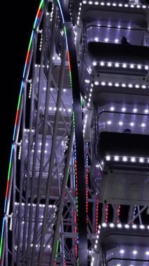 Gece gökyüzüne karşı dönme dolap. Büyük, detaylı dönme dolap eğlence, rahatlama ve eğlence parkı atmosferini simgeliyor..