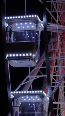 Gece gökyüzüne karşı dönme dolap. Büyük, detaylı dönme dolap eğlence, rahatlama ve eğlence parkı atmosferini simgeliyor..