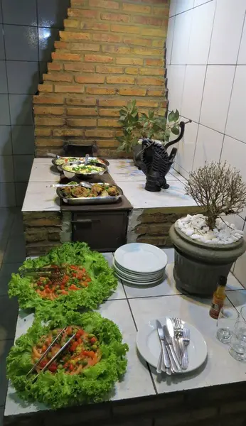 Pirinç, domuz eti, yumurtalı fasulye ve marul, domates, zeytin ve biberli salata ile odun yakan bir sobanın üstünde akşam yemeği pişirildi..