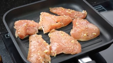  Raw chicken breast frying on grill pan clipart