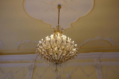 Güzel altın kristal avize beyaz bir tavanda.