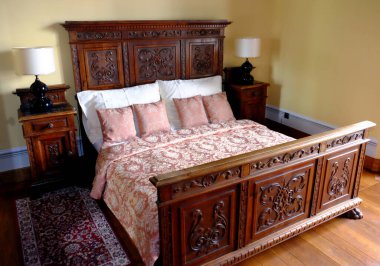 Yatak odasının içi dekoratif mobilya ve yastıklarla dolu.