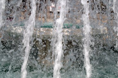 Çeşmenin arka planına su sıçrıyor.