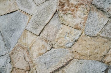 Doğal granit duvar. Kaba doğal taş. Krem rengi tuğla kaplama duvar dokusu arkaplanı.