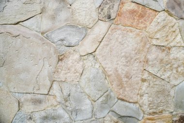 Doğal granit duvar. Kaba doğal taş. Krem rengi tuğla kaplama duvar dokusu arkaplanı.