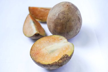 Beyaz arka planda izole edilmiş olgun sapodilla meyvesi. Dilimlenmiş taze sapodilla