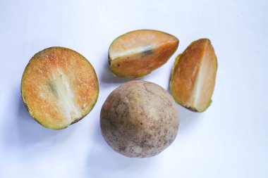 Beyaz arka planda izole edilmiş olgun sapodilla meyvesi. Dilimlenmiş taze sapodilla