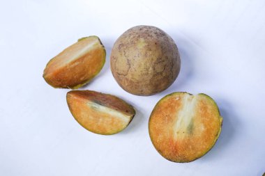 Beyaz arka planda izole edilmiş olgun sapodilla meyvesi. Dilimlenmiş taze sapodilla