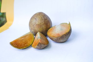 Beyaz arka planda izole edilmiş olgun sapodilla meyvesi. Dilimlenmiş taze sapodilla