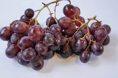 Beyaz arka planda taze üzümler. Bu fotoğraf poster tasarımlarında, tebrik kartlarında veya meyvelerle ilgili makalelerde kullanılmak için idealdir..