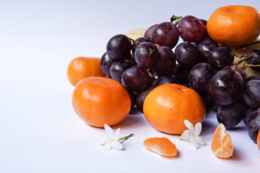 Beyaz zemin üzerinde üzüm ve armut bulunan Mandalina veya Mandarin portakalı kavramı, meyveler ve diğerleri hakkında makaleler için bir illüstrasyon olarak tasarım ihtiyaçları için uygundur..