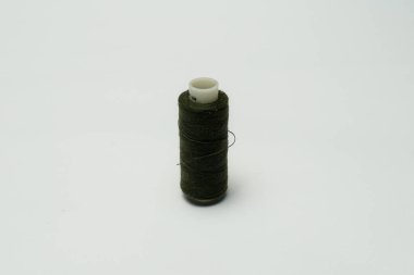 Beyaz arkaplanı olan bir dikiş makinesine dikiş dikmek için renkli dikiş ipliği aksesuarları