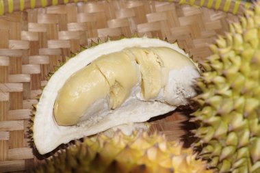 Güneydoğu Asya 'da Durian meyvesi, Endonezya, meyvelerin kralı, durian eti beyaz bir arka planda ve bambu bir paspasın üzerinde düzenlenir ve görülür..