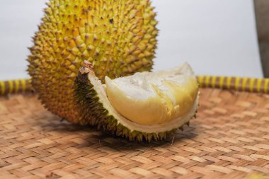 Güneydoğu Asya 'da Durian meyvesi, Endonezya, meyvelerin kralı, durian eti beyaz bir arka planda ve bambu bir paspasın üzerinde düzenlenir ve görülür..