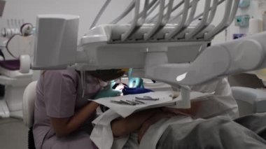 Ortodontistler randevusundaki bir kız diş tellerinin çıkarılması için gerekli prosedürleri alır.