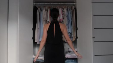 Tarz sahibi genç bir kadın, yeni bir etkinlik için mükemmel bir görünüm arayışında, iyi organize edilmiş gardırobunu karıştırıyor. Seçeneklere rağmen, giyecek bir şeyi yokmuş gibi hissediyor.