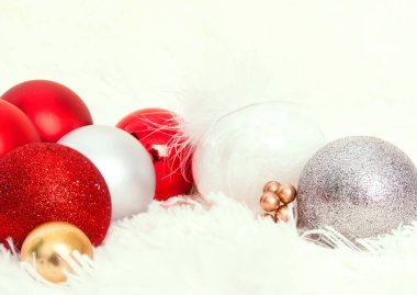 Noel kartpostalı manzarası. Beyaz arkaplanda kırmızı, beyaz ve gümüş Noel topları olan beyaz kürk yüzeyi