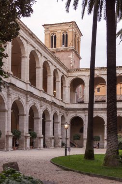 Roma şehrindeki kilisenin girişi kemerler, sütunlar ve palmiye ağaçları ile çevrili.