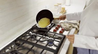 Mutfaktaki tavada krep pişiren kadın, aileye kahvaltı hazırlayan genç kız.