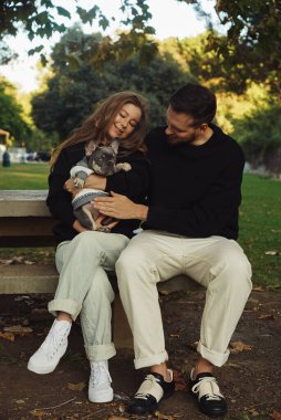 Aile bir köpekle kucaklaşır, parkta yürür, sahibi olan Fransız bulldog köpeğinin dışında gezer, evcil hayvanı olan genç bir çift evde vakit geçirir, mutlu insanlar köpekle güler.
