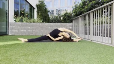 Pilates yoga yapan bir kadın, esneme egzersizleri yapan genç bir kadın, ev sağlığı, spor paspası üzerinde vücut esneme hareketleri yapan güzel bir kadın.