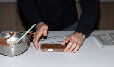 Şef çikolata yapıyor, el yapımı çikolata kalıba dökülüyor, erkek eli ve çikolatası, Dubai çikolatası
