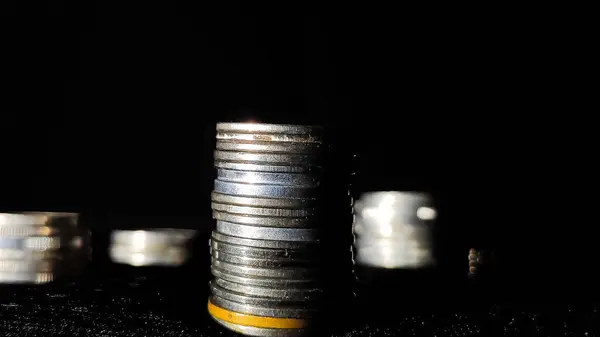 İş büyümesini simgeleyen para yığınları siyah arkaplanlı.