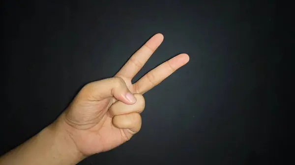 İki parmağın havada olması barış demektir. Siyah arkaplanda izole