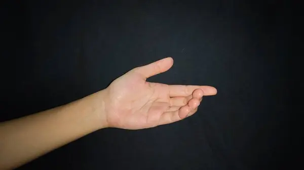 Siyah arka planda izole edilmiş bir jest sunan el.