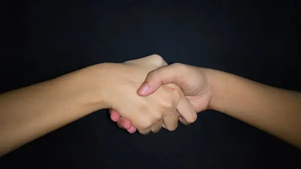 Bir erkekle kadın arasında eller titriyor. Siyah arkaplanda izole