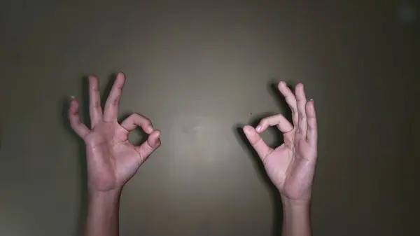 Tamam sembolü olan iki elini kaldır.