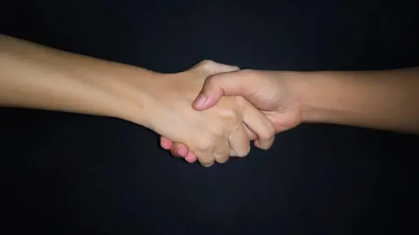 Bir erkekle kadın arasında eller titriyor. Siyah arkaplanda izole