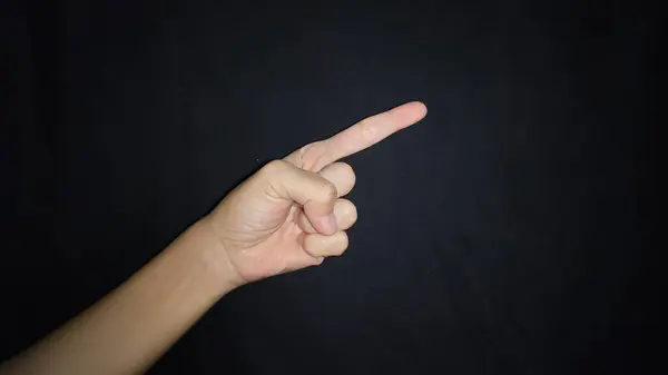Bir şeyi işaret eden bir el. Siyah arkaplanda izole