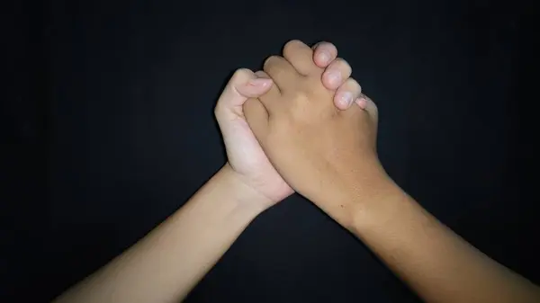 İki el titriyor, bu da arkadaşlık demek. Siyah arka planda izole edilmiş.