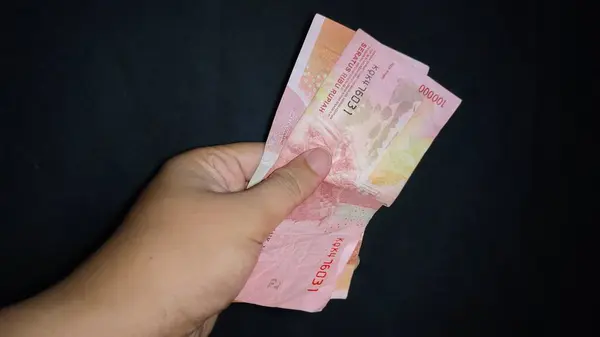 Biraz para tutarak. Siyah arkaplanda izole