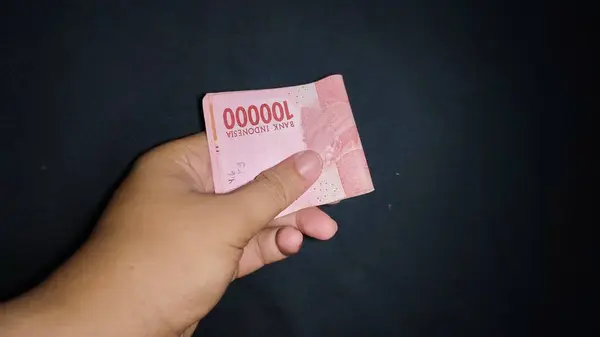 Biraz para tutarak. Siyah arkaplanda izole