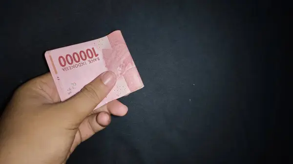 Biraz para tutarak. Siyah arkaplanda izole