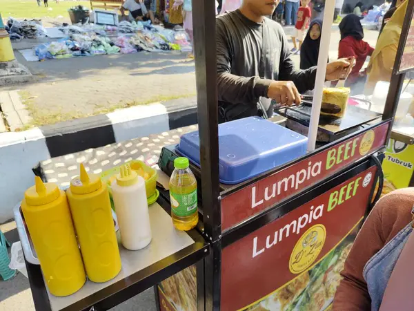 Sukoharjo, Endonezya - 13 Ekim 2024: Bir yemek festivalinde bahar böreği satan bir sokak yemeği satıcısı