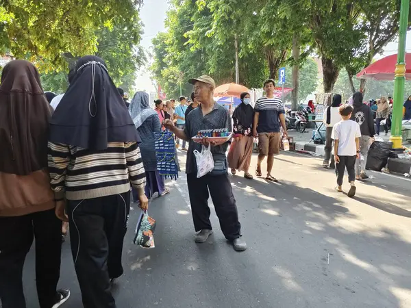 Sukoharjo, Endonezya - 13 Ekim 2024: Yaşlı adam inanılmaz bir kalabalık ve heyecanla Gıda Festivali 'nde kriket sattı.