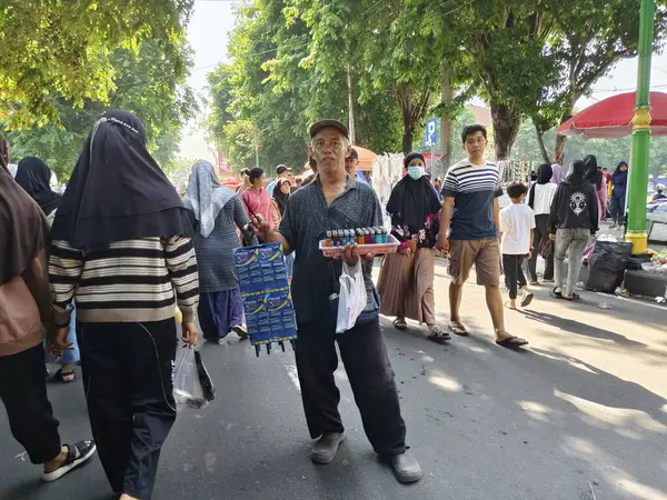 Sukoharjo, Endonezya - 13 Ekim 2024: Yaşlı adam inanılmaz bir kalabalık ve heyecanla Gıda Festivali 'nde kriket sattı.