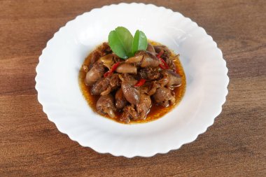 Kızarmış tavuk kalbi beyaz tabakta servis ediliyor.