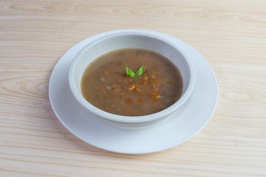 Bubur Kacang Hijau ya da Hindistan cevizi sütü, pandan yaprağı ve zencefilli Mung fasulyeli Endonezya tatlı lapası. Beyaz kasede servis edilir..