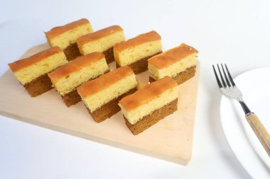 Mandarin Keki, çikolata katmanlı ve çilek reçeli ile dolu sarı bir sünger kek, beyaz arka planda bir sırada düzenlenir..