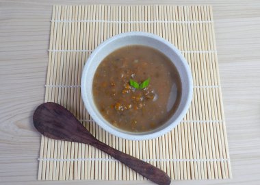 Bubur Kacang Hijau or Indonesian dessert porridge of mung beans with coconut milk, pandan leaf and ginger. clipart