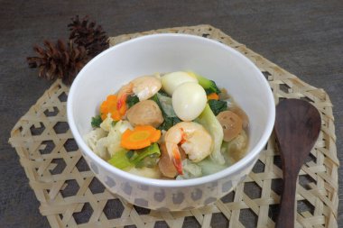 Capcay, kızarmış sebze, köfte, karides ve yumurta. Beyaz bir kasede servis edildi..