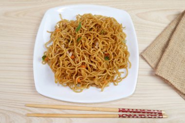 Lezzetli kızarmış erişte, beyaz tabakta servis edilir.