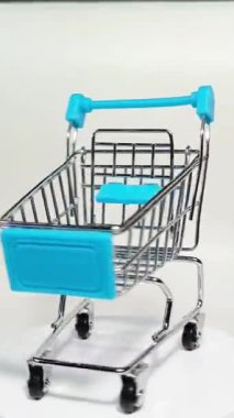 Beyaz arka planda mini alışveriş arabası