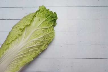 Beyaz hardal (sawi putih) veya Çin lahanası veya Napa lahanası beyaz ahşap masaya izole edilmiş..