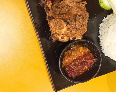 Ayam Bakar Taliwang. Taliwang usulü ızgara tavuk. Bir tabakta pirinç, sebze ve biber sosu ile servis edilir..