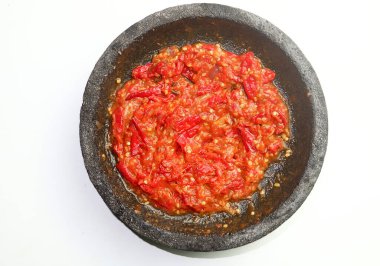 Endonezya 'dan gelen sambal ya da geleneksel biber sosu, taş havan ve tokmak kullanılarak yeni yapılmış, beyaz arka planda izole edilmiş..